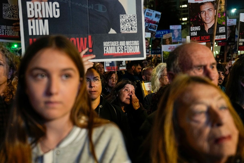 Families and supporters of Israeli captives held by the Palestinian resistance in Gaza hold their photos and shout slogans during a rally calling for their release, in 'Tel Aviv', occupied Palestine, December 30, 2023  (AP)