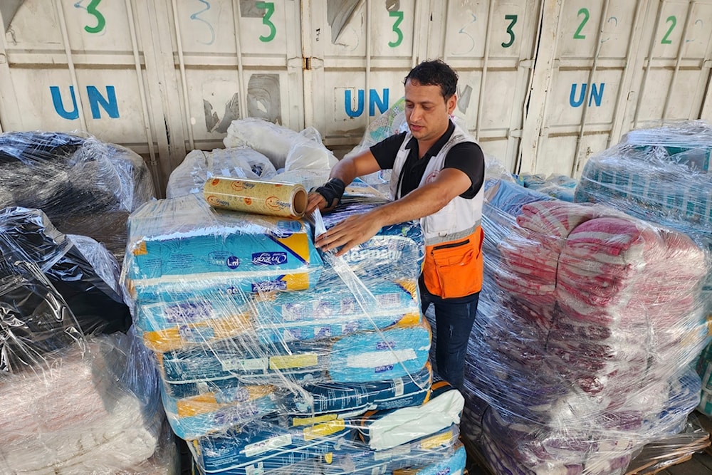 United Nations and Red Crescent workers prepare the aid for distribution to Palestinians at UNRWA warehouse in Deir Al-Balah, Gaza Strip, occupied Palestine, on Monday, Oct. 23, 2023. (AP)