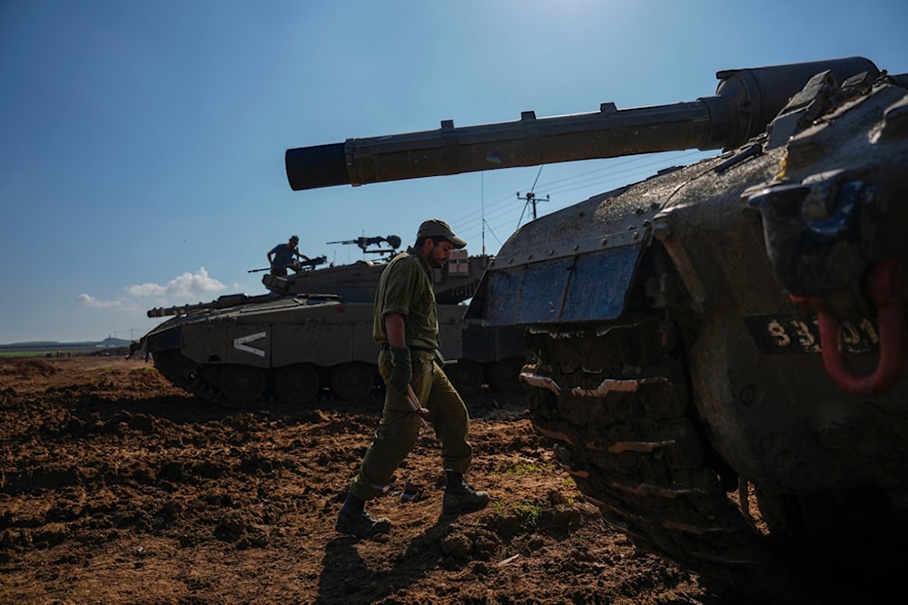 Israeli occupation soldiers work on their tank in the Gaza Strip border area in occupied Palestine, Thursday, Jan. 4, 2024. (AP)