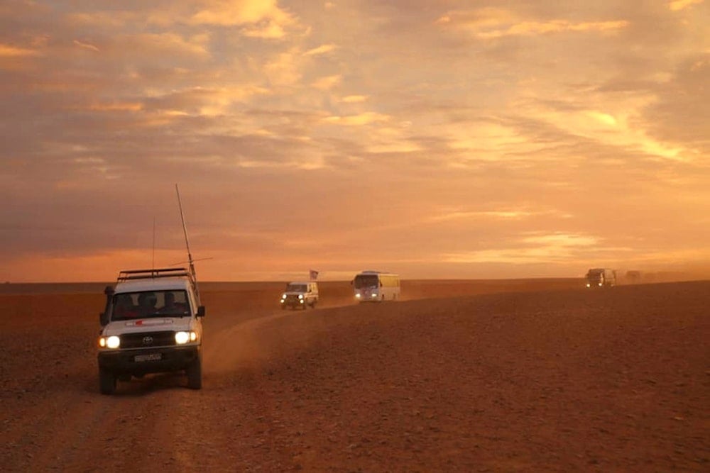 This photo released by the Syrian Arab Red Crescent, shows a convoy of vehicles of the Syrian Arab Red Crescent driving in the Syrian desert heading to Rukban camp, Nov. 4, 2018. (AP)