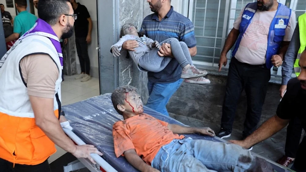 Medics transport wounded children into al-Shifa hospital following Israeli strikes in Gaza City on October 10, 2023. (AFP)