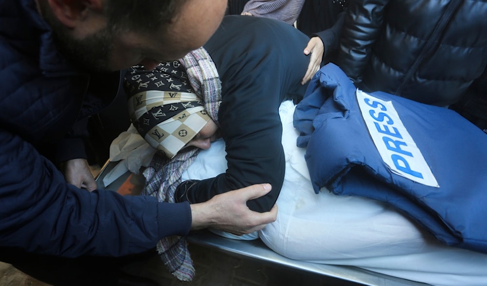 A relative mourns Palestinian journalist Akram Al-Shafi'i, killed in the Israeli bombardment of the Gaza Strip, in a morgue of the European Gaza Hospital in Rafah, Saturday, Jan. 6, 2024. (AP)