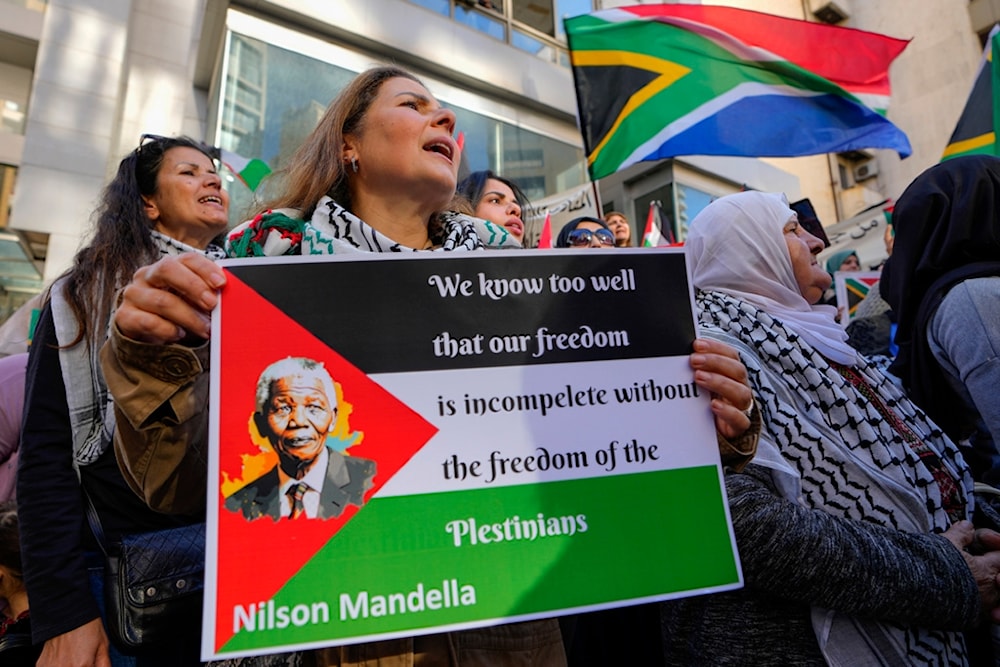 A woman holds a Palestinian flag with a Picture of former South Africa's president Nelson Mandela, during a protest outside the South African consulate in Beirut, Lebanon, Friday, Jan. 19, 2024. (AP)