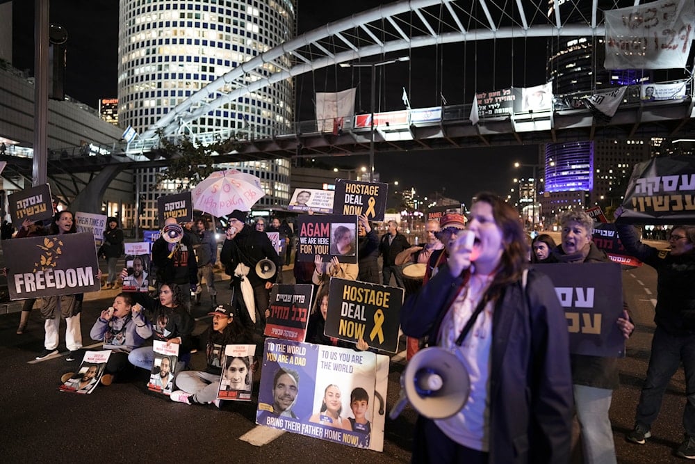 Israeli settlers block a highway as they demand the release of captives from Gaza during a rally in 'Tel Aviv', occupied Palestine, February 4, 2024 (AP)