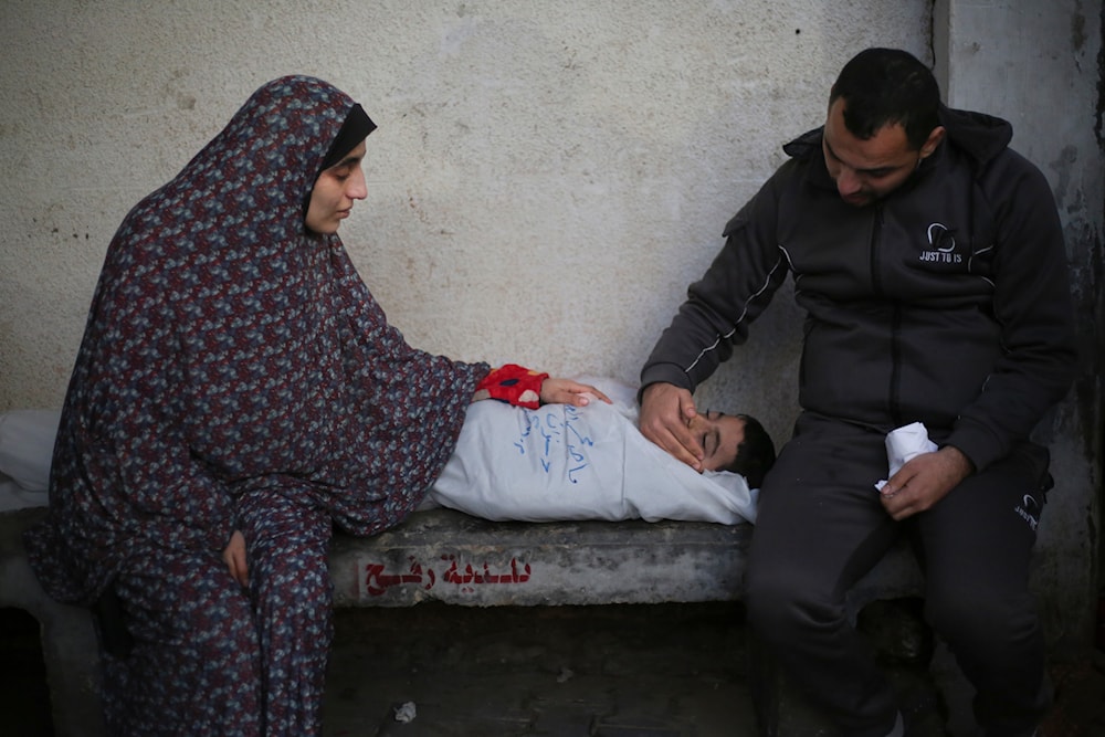 Palestinians mourn a child killed in the Israeli bombardment of the Gaza Strip at a hospital morgue in Rafah, Monday, Feb. 12, 2024. (AP)