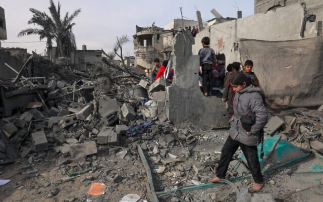 Palestinian children inspect the damage in the rubble of a residential destroyed by Israeli airstrikes on Rafah, in the southern Gaza Strip on February 12, 2024. (AFP)