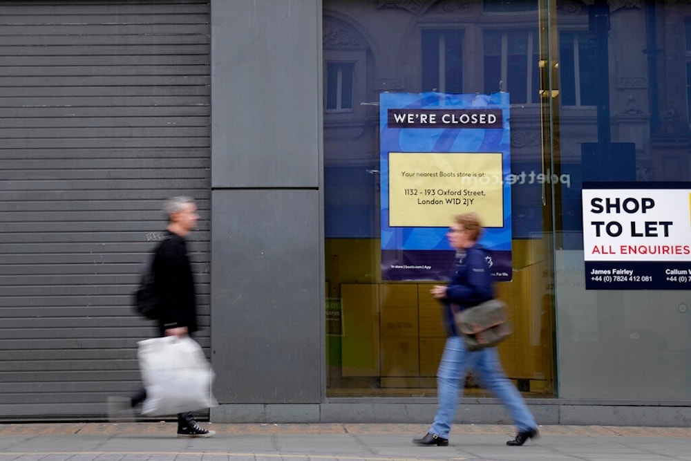 Pedestrians pass a closed retail unit on Oxford Street in London, Friday, Nov. 11, 2022 (AP)