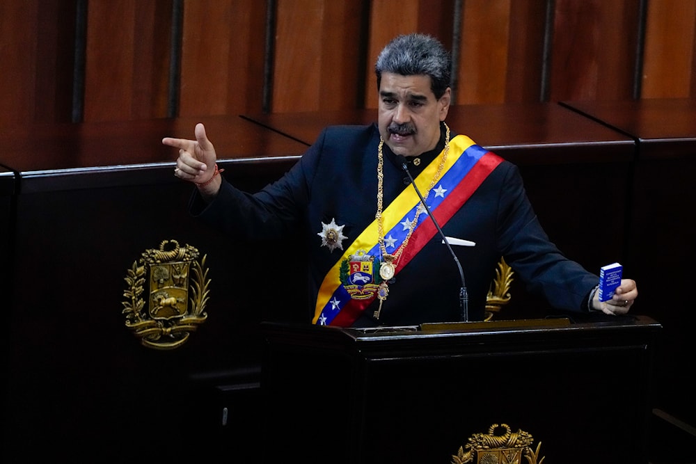 Venezuelan President Nicolas Maduro holds a small copy of his nation's constitution during a ceremony marking the start of the judicial year at the Supreme Court in Caracas, Venezuela, Wednesday, Jan. 31, 2024(AP)