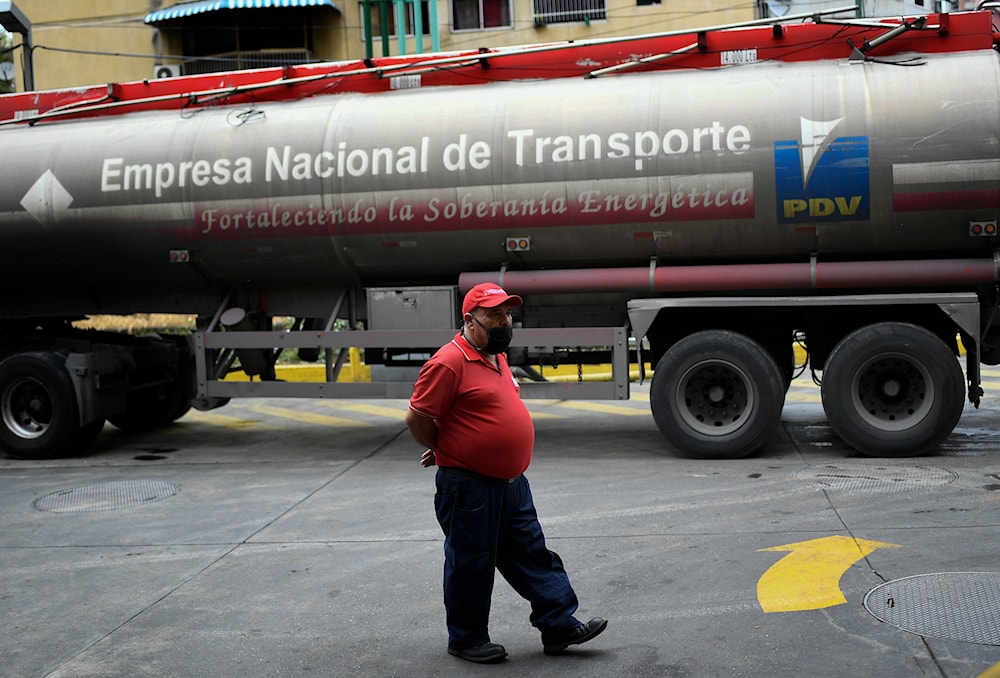 A worker wearing a face mask amid the coronavirus pandemic waits while a tanker truck supplies gasoline to a state oil company gas station in Caracas, Venezuela, Sunday, May 31, 2020(AP)