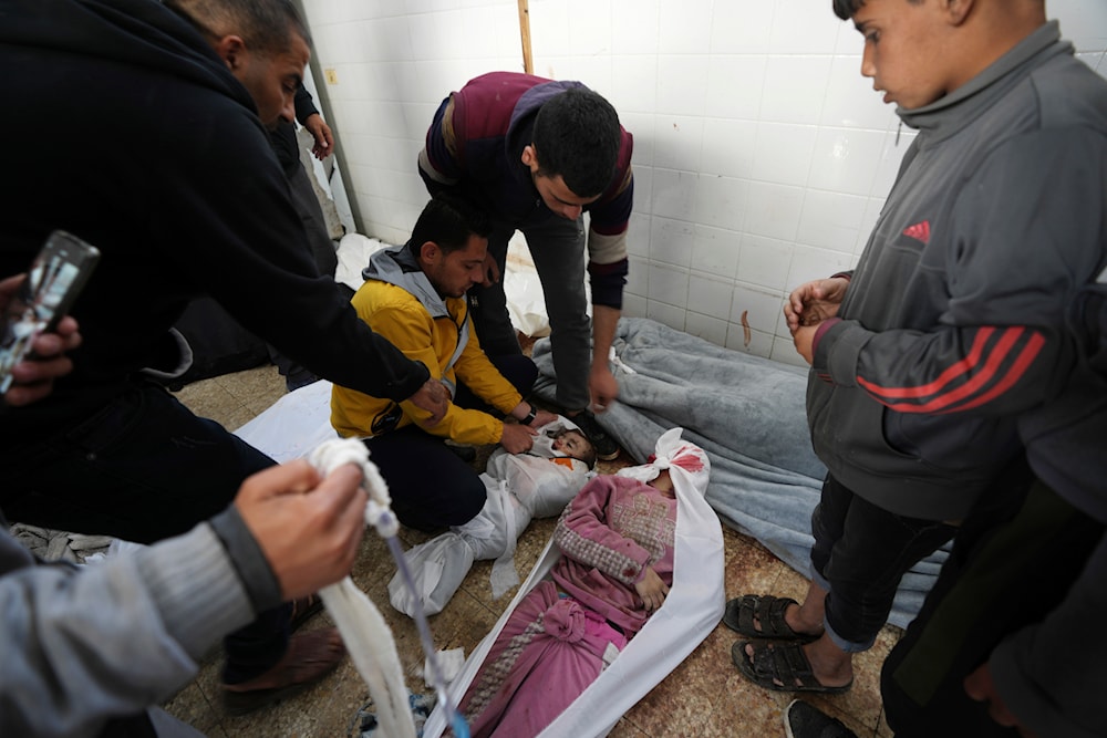 Palestinians mourn over their relatives killed in the Israeli bombardments of the Gaza Strip at Al Aqsa Hospital in Deir al Balah, Gaza, on Sunday, Feb. 18, 2024. (AP)
