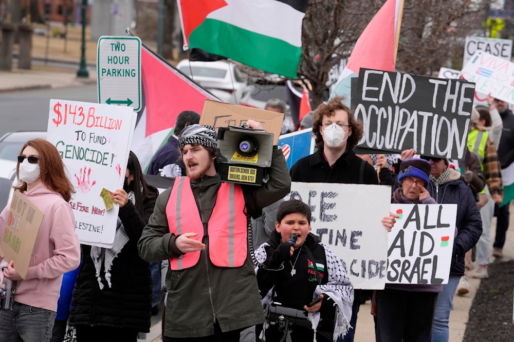 Pro-Palestinian demonstrators display signs while marching during a protest held to call for a cease fire in the war in Gaza, Sunday, Feb. 11, 2024, in Braintree, Massachusetts. (AP)