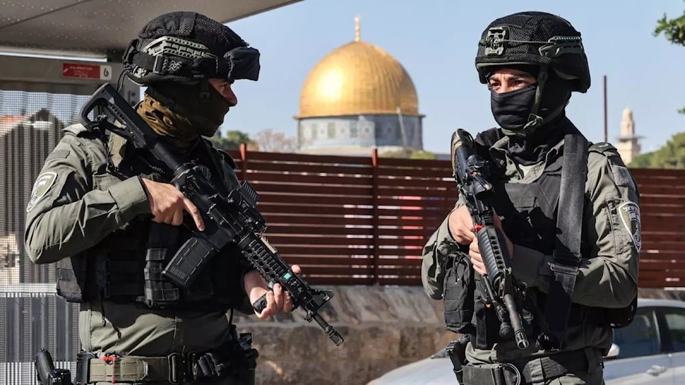 Israeli occupation forces block a street in al-Quds as Palestinians take part in Friday noon prayers on 24 November 2023, following an age restriction for worshippers wanting to access Al-Aqsa Mosque. (AFP) 