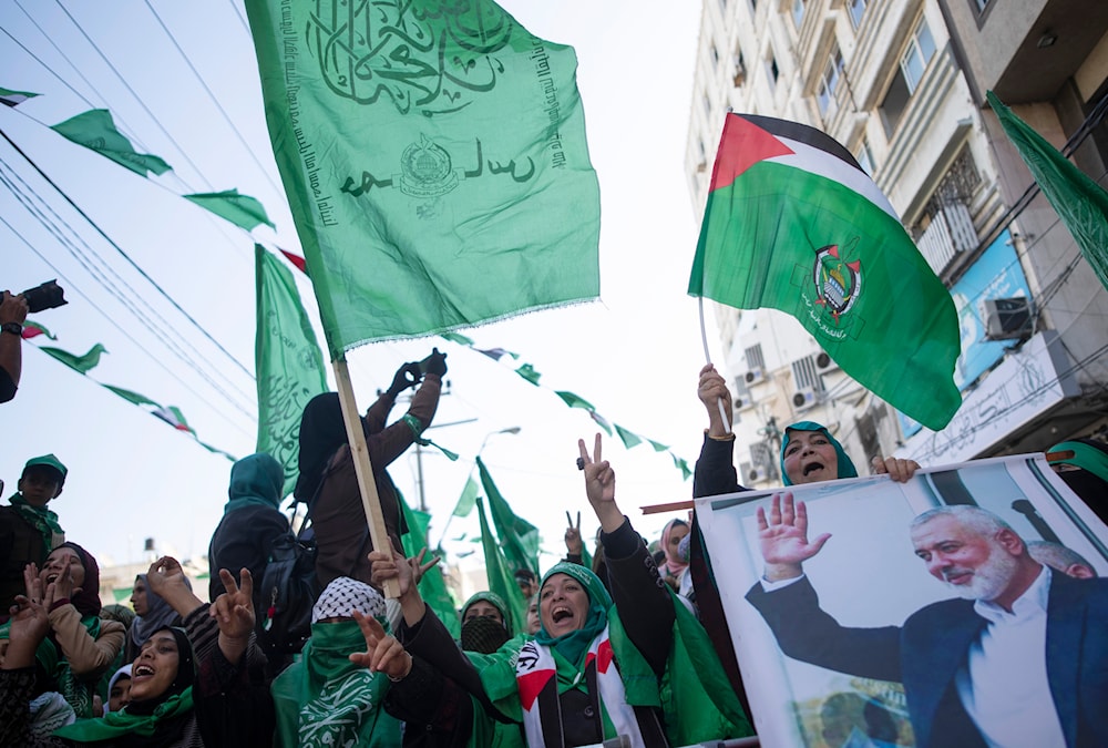 Palestinian women, one holding a picture of Hamas movement chief Ismail Haniyeh, attend a mass rally marking the 32nd anniversary of the founding of Hamas in Gaza, December 14, 2019, in Gaza City (AP)