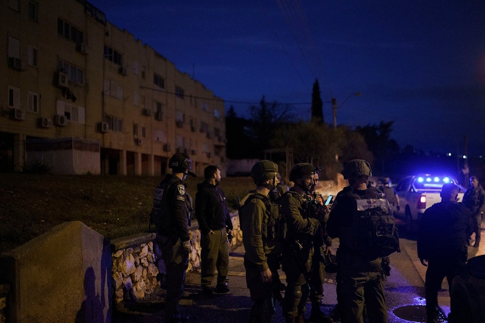 Israeli occupation forces stand in a settlement that was hit by a rocket fired from Lebanon, in 'Kiryat Shmona', northern occupied Palestine, January 11, 2024 (AP)