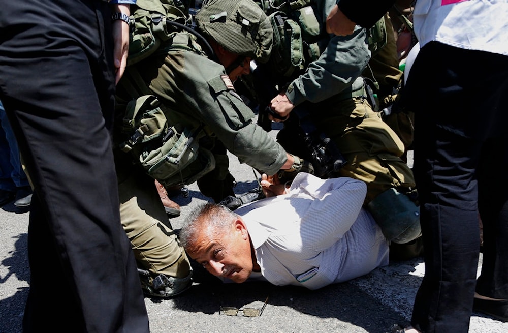 Israeli solders arests a Palestinian protestor during protest in solidarity with Palestinian prisoners on hunger strike in Israeli jails near the settlement of 
