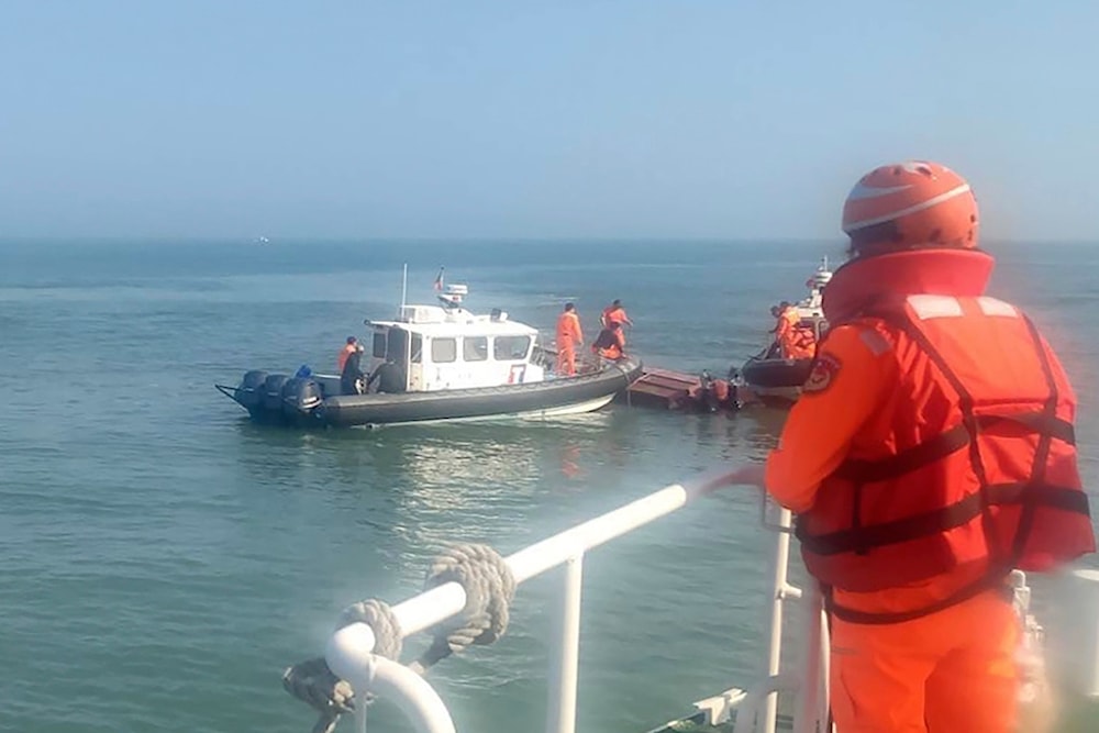 Handout photograph provided by Taiwan Coast Guard Administration, Taiwanese coast guards inspect a vessel that capsized during a chase off the coast of Kinmen archipelago in Taiwan, Feb. 14, 2024. (AP
