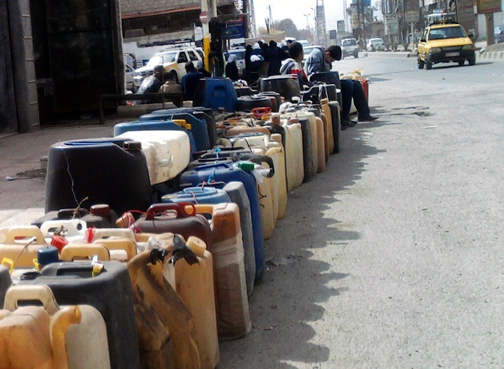 Syrian boys sit on empty gallons as they wait in a long queue to fill gasoline near a gas station in Damascus, Syria, Wednesday, March 7, 2012. (AP)