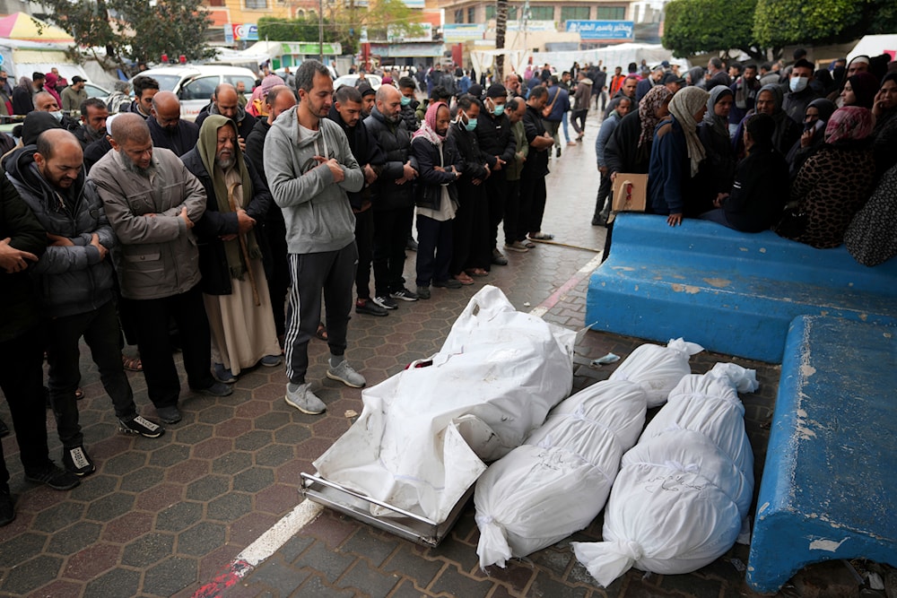 Palestinians pray for the relatives martyred in the Israeli bombardments of the Gaza Strip in front of the morgue at Al Aqsa Hospital in Deir al Balah, Gaza Strip, on Sunday, Feb. 18, 2024. (AP)