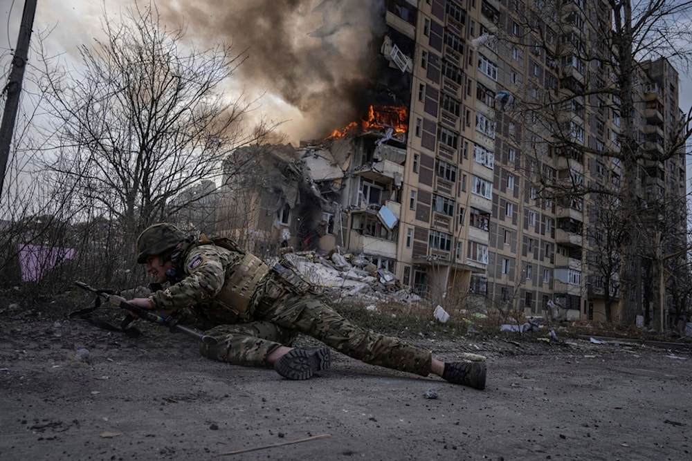 A Ukrainian police officer takes cover in front of a burning building that was hit in a Russian airstrike in Avdiivka, Ukraine, Friday, March 17, 2023. (AP)
