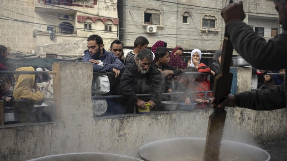 Forcibly displaced Palestinians due to the ongoing Israeli genocide line up for a free meal in Rafah, Gaza Strip, Thursday, Dec. 21, 2023. (AP)