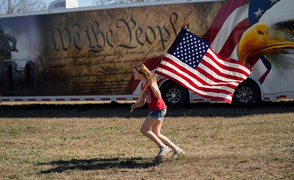 Lola Lee, from New Mexico, runs with a U.S. flag during a 