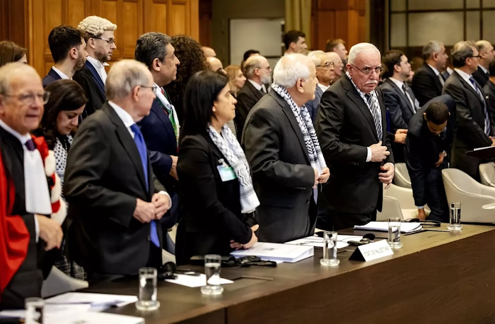 Minister of Foreign Affairs of the Palestinian Authority Riyad al-Maliki (R) stands with colleagues at the International Court of Justice (ICJ) in The Hague, 19 February 2024 (AFP)