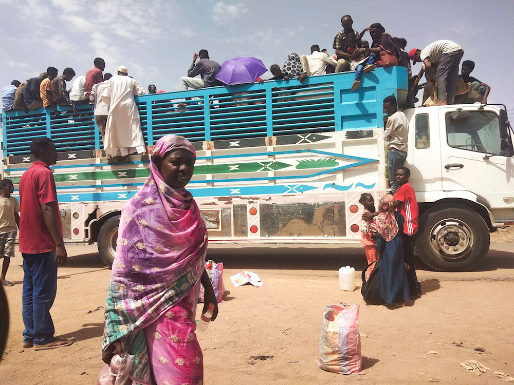 People board a truck as they leave Khartoum, Sudan, on June 19, 2023 (AP)