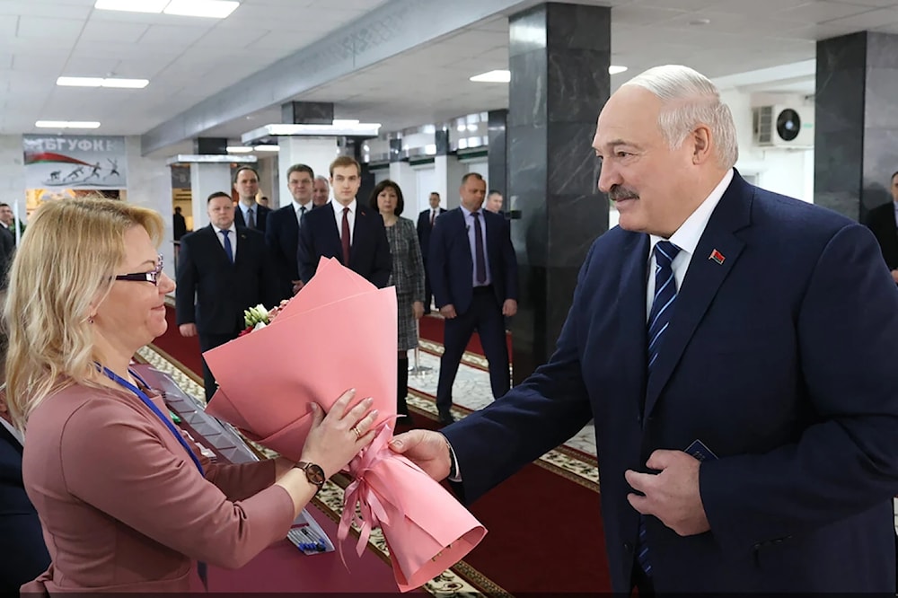 In this photo provided by the Belarusian Presidential Press Service, Belarus President presents flowers to an election commission official head of voting at a polling station in Minsk, Sunday February 25, 2024. (AP)