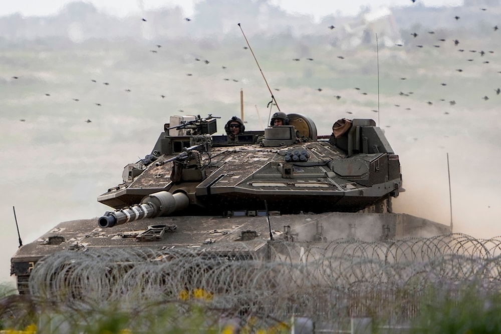 Israeli occupation soldiers drive a tank on the 
