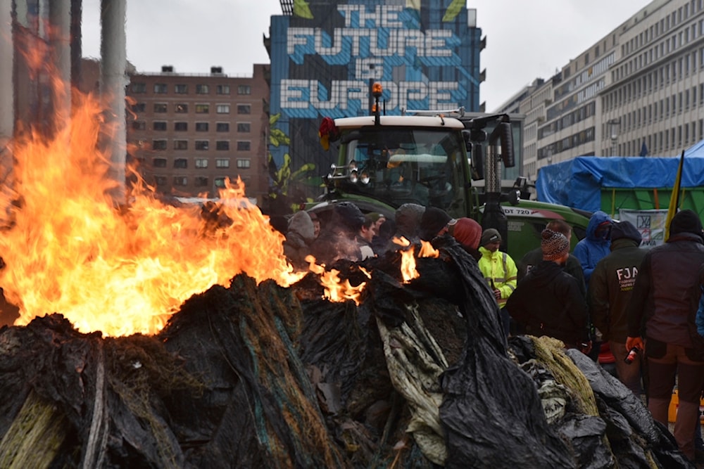 Protestors light fires during a farmers demonstration in the European Quarter outside a meeting of EU agriculture ministers in Brussels, Monday, Feb. 26, 2024. (AP)