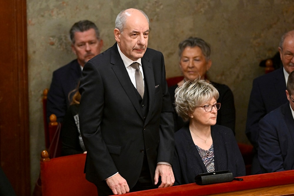Tamas Sulyok, left, the head of Hungary's Constitutional Court, stands before a parliament vote to elect him as president, in Budapest, Hungary, Monday, Feb 26, 2024 (AP)