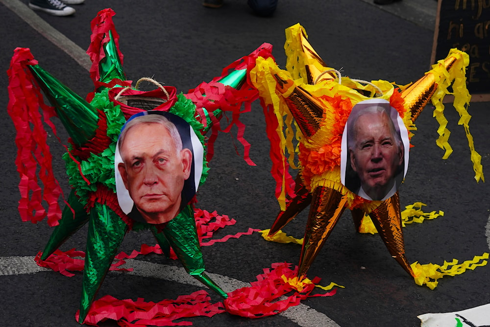 Demonstrators place pictures of Israeli Prime Minister Benjamin Netanyahu, left, and US President Joe Biden on pinatas during a protest against the war on Gaza outside the US Embassy, in Mexico City, January 7, 2024 (AP)