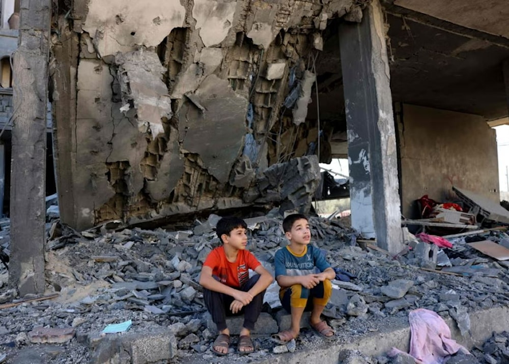 Palestinian children sitting on the rubble of a residential building destroyed by an Israeli airstrike (AFP via Getty Images)