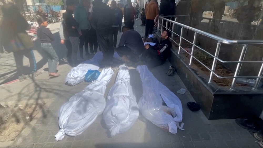 Palestinian martyrs are wrapped in white shrouds on the ground outside al-Shifa Hospital in Gaza City on Thursday, February 29, 2024. (AP)