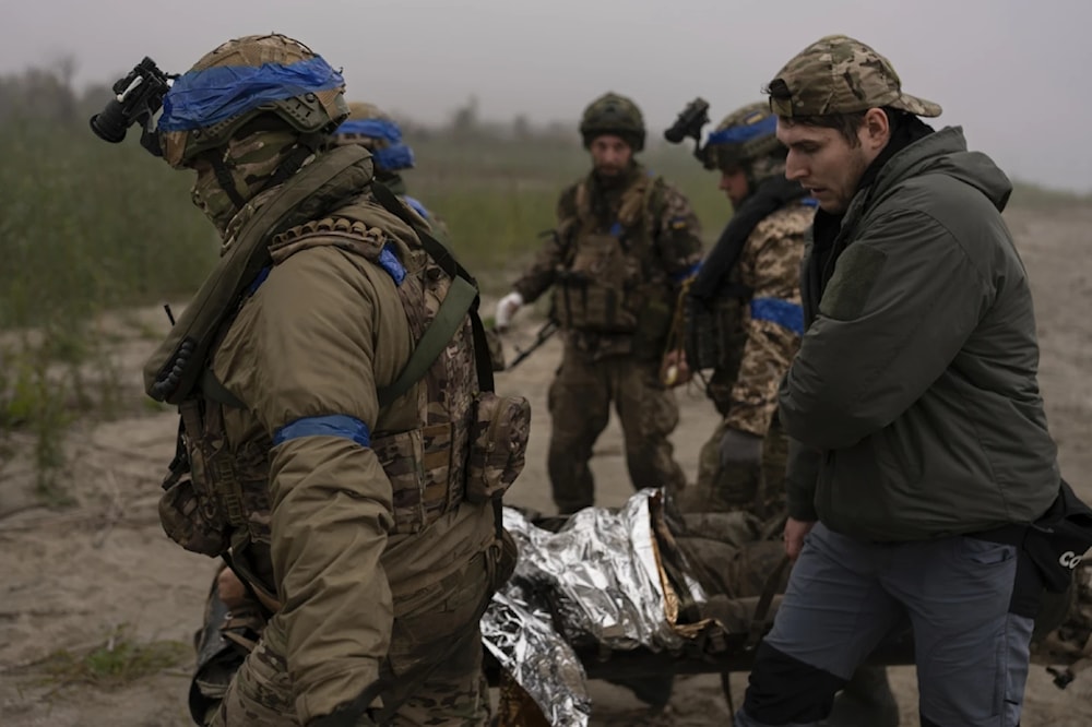 Ukrainian servicemen evacuate injured comrade at the frontline close to the Dnipro near Kherson, Oct. 14, 2023. (AP)