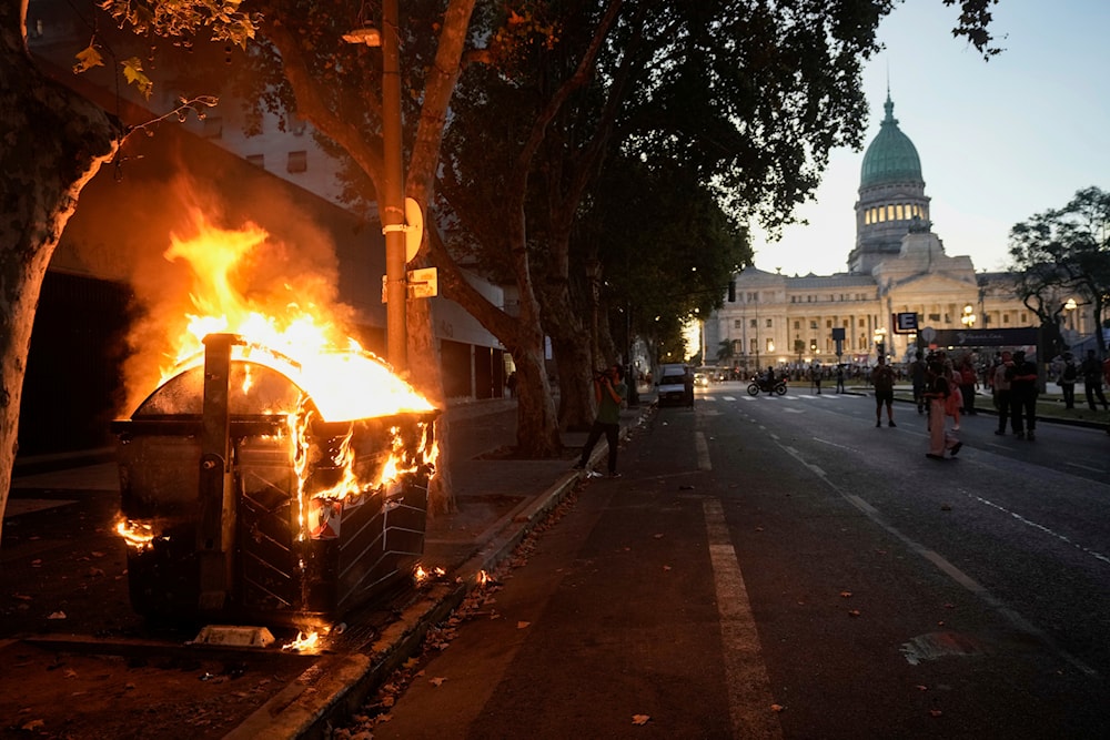 A trash bin goes up in flames on the avenue leading to Congress after a bill promoted by Argentine President Javier Milei was approved in general by the lower house of Congress, in Buenos Aires, Argentina, Friday, Feb. 2, 2024(AP)