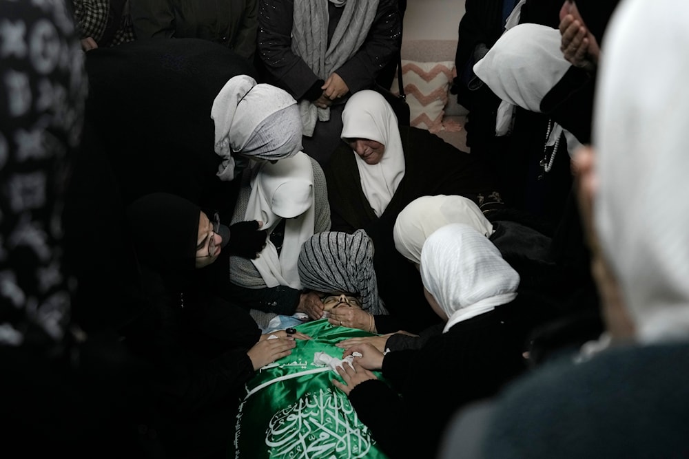 Palestinian women gather around the body of Muhammad Jalamneh, in the morgue of Ibn Sina Hospital after he was killed in an Israeli military raid in the West Bank town of Jenin, Tuesday, Jan. 30, 2024(AP)