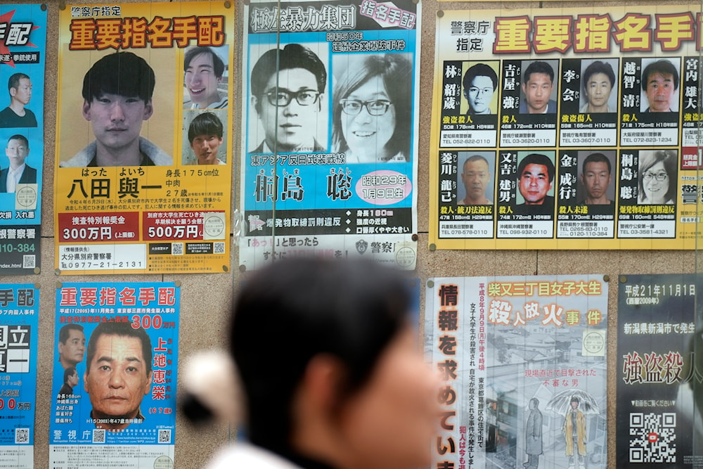 A wanted poster, center top, for Satoshi Kirishima, a fugitive who has long been wanted for one of a series of bombings in Japan, is displayed outside a Police station Friday, Feb. 2, 2024, in Tokyo(AP)