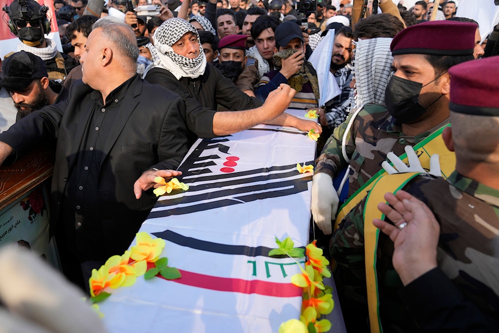 Iraqis attend the funeral of a fighter with the Kataib Hezbollah, who was killed in a US airstrike, in Baghdad, Iraq, January 25, 2024 (AP)