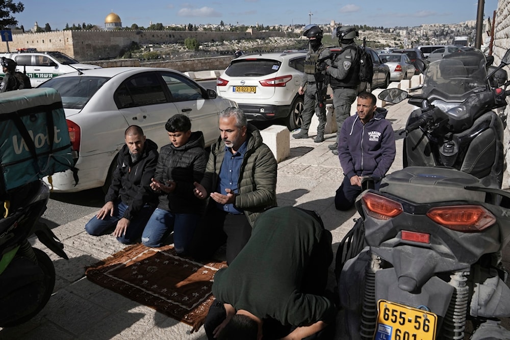 Palestinian Muslim worshipers who were prevented from entering the Al-Aqsa Mosque, pray outside Jerusalem's Old City as Israeli occupation forces surround them Friday Dec. 22, 2023. (AP)