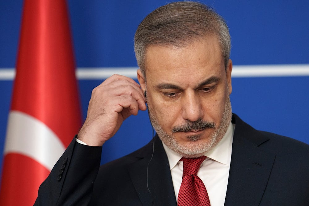 Turkish Foreign Minister Hakan Fidan adjusts his headphones during joint statements with his Romanian counterpart Luminita-Teodora Odobescu in Bucharest, Romania, January 31, 2024 (AP)