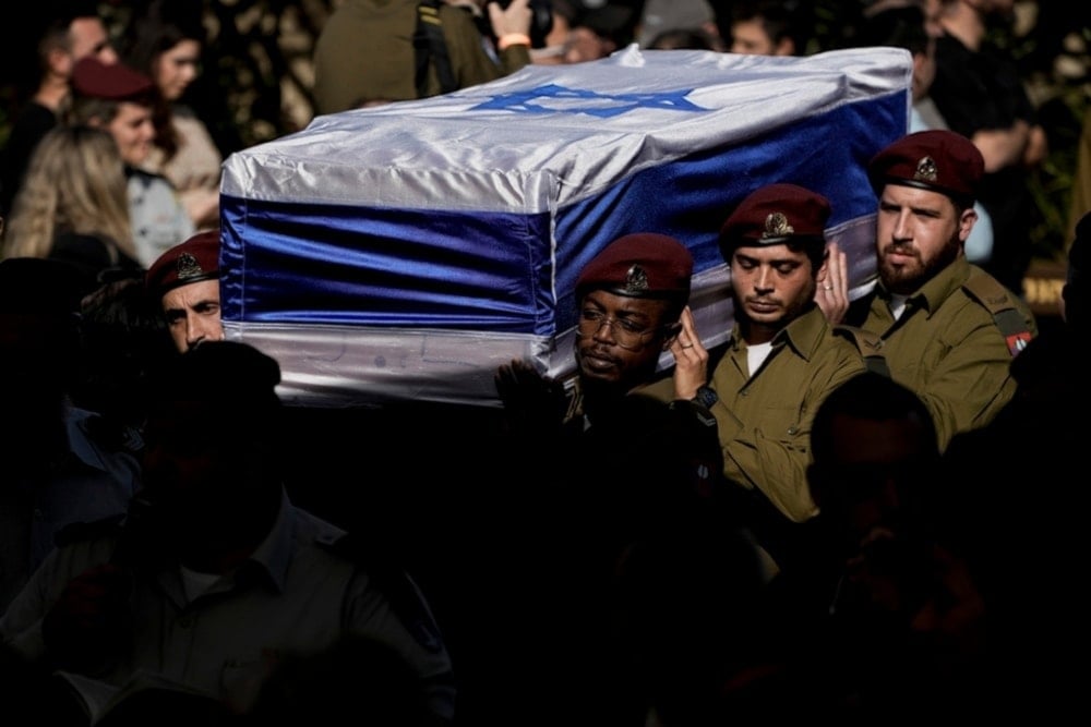 Israeli occupation forces carry the flag-draped casket of An Israeli occupation office who was killed in confrontations with the Palestinian Resistance in Gaza, December 8, 2023. (AP)