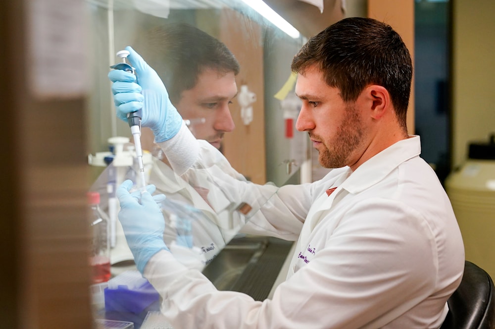 Research scientist Kevin Potts uses ovarian cancer cells to set up an experiment at UW Medicine's Cancer Vaccine Institute Thursday, May 25, 2023, in Seattle.(AP)