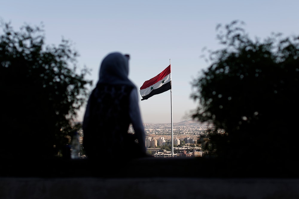 A young woman sits in a public garden overlooking the Syrian capital Damascus, Syria, July 24, 2019 (AP)