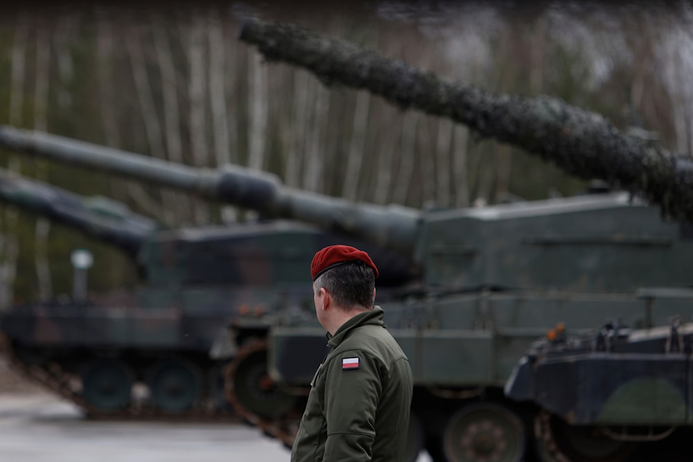 A Polish soldier walks next to the Leopard 2 tanks during a training at a military base and test range in Swietoszow, Poland, Monday, Feb. 13, 2023. (AP)