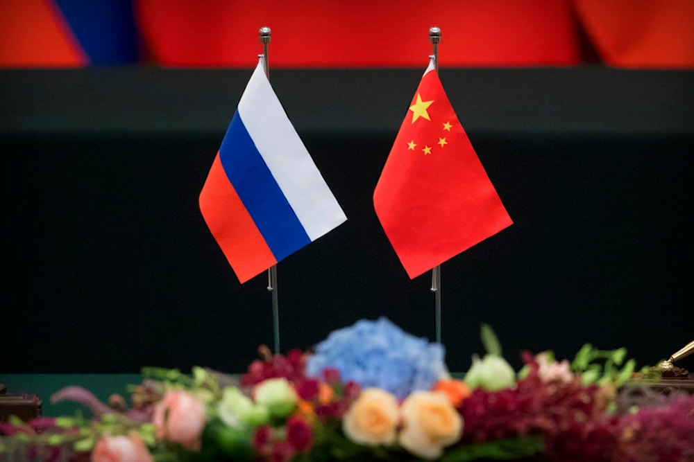 Russian, left, and Chinese flags sit on a table before a signing ceremony at the Great Hall of the People in Beijing, Friday, June 8, 2018. (AP)