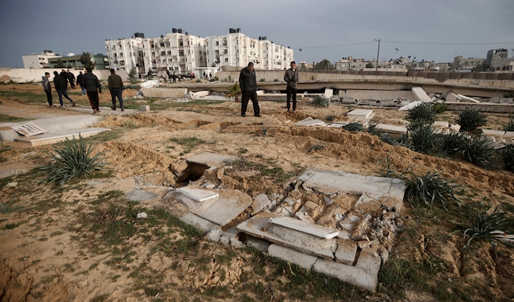 Palestinians inspect damaged graves following an Israeli occupation tank raid over a cemetery in Khan Younis refugee camp, southern Gaza Strip, Palestine, Wednesday, Jan. 17, 2024. (AP)