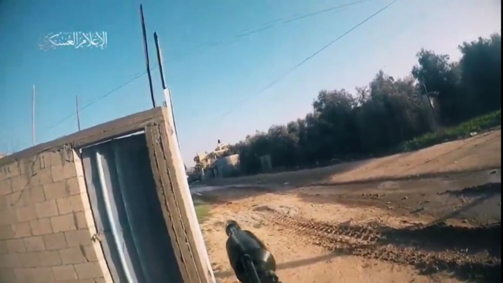 A screengrab from a video posted by Al-Qassam Military Media depicting one of its fighters firing an RPG at an Israeli tank (Military Media)