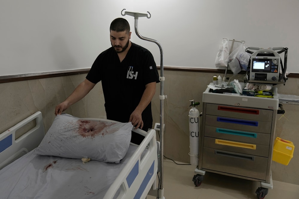 A staff member at Ibn Sina Hospital displays a blood-stained pillow following a deadly Israeli military raid in the West Bank town of Jenin, Tuesday, Jan. 30, 2024. (AP)