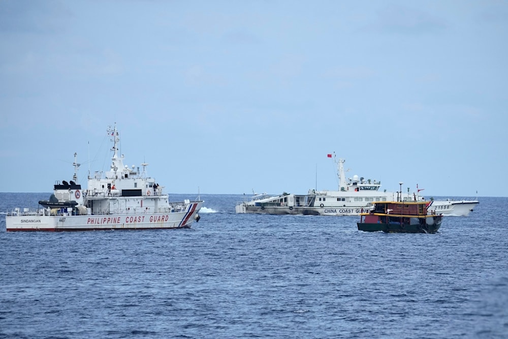 A Philippine coast guard and a supply boat maneuver as a Chinese coast guard ship tries to block its way near Second Thomas Shoal, at the disputed South China Sea on Tuesday, Aug. 22, 2023 (AP)